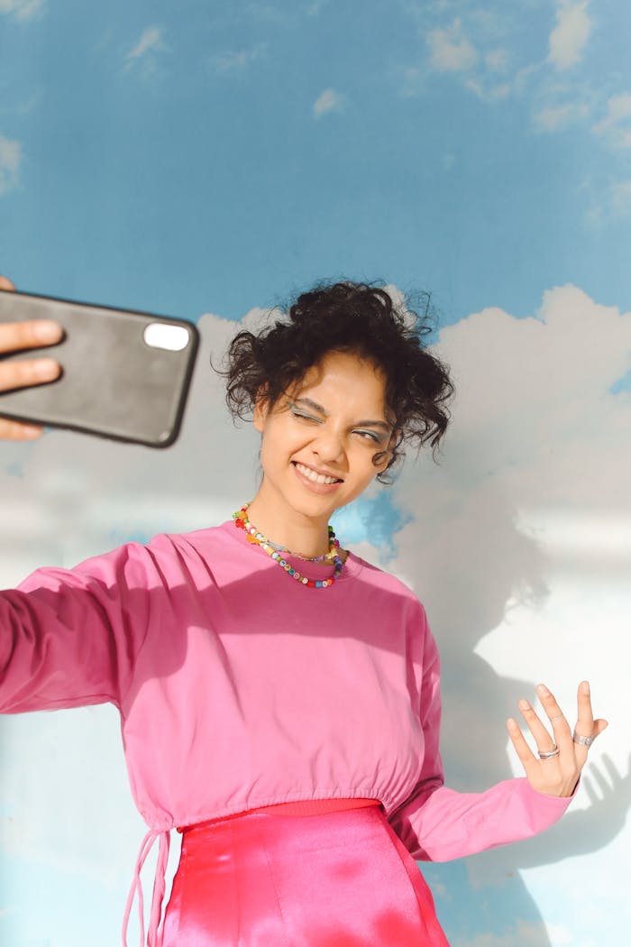 A Girl in Pink Sweater Taking Selfie